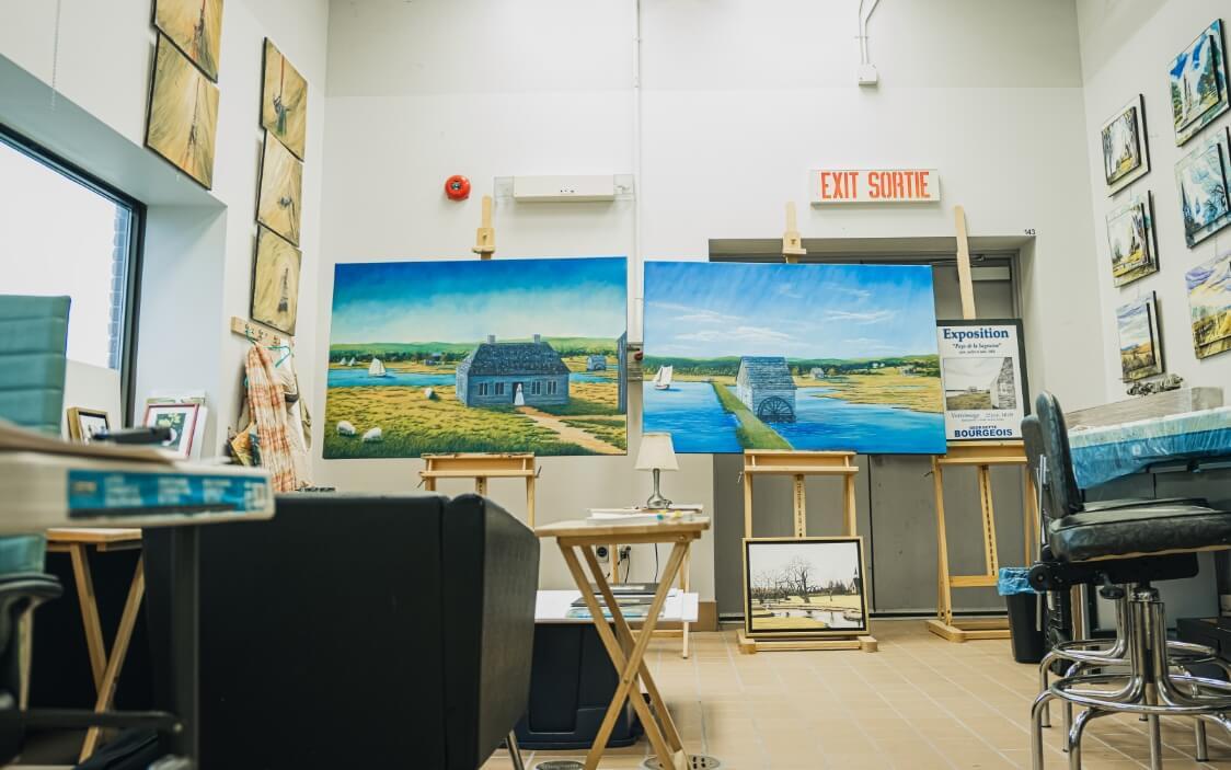 Painting studio with easels holding large paintings