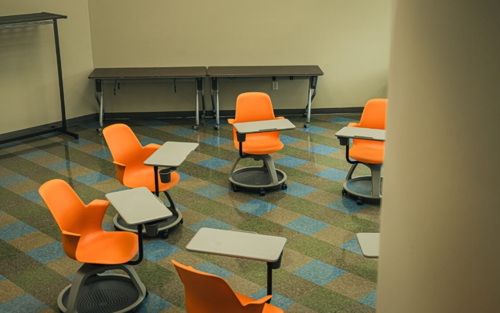 Orange chairs with attached tables arranged in a circle